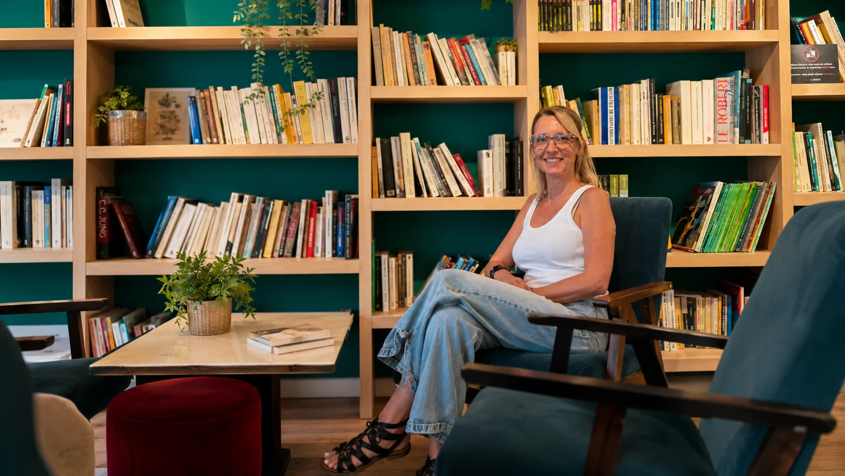 Nathalie assise devant une grande bibliothèque